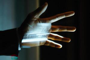 Illuminated hand displaying technology in a dark room, showcasing innovation and creativity photo