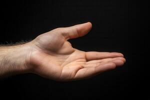 Open hand gesture against a dark background, symbolizing offering or communication photo