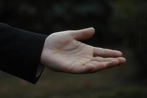 Open hand reaching out against a blurred natural background, conveying invitation or support photo