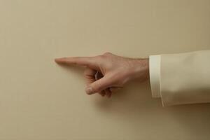 Hand pointing towards a blank wall, suggesting communication or direction in a minimalist setting photo