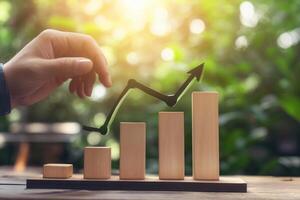 Hand adjusting a wooden graph with an upward trend in a lush green outdoor setting photo