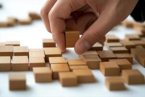 Person arranging wooden blocks on a table, showcasing creativity and focus in play photo