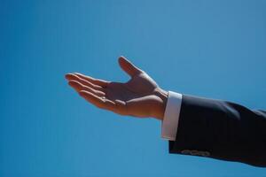 Outstretched hand against a clear blue sky, symbolizing openness and invitation photo