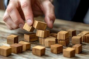 Person stacking wooden blocks on a rustic table, showcasing focus and dexterity in play photo