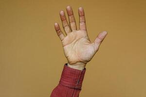 Hand raised in greeting against a warm, neutral background, symbolizing connection and communication photo
