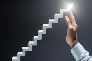 Hand reaching towards a glowing arrow above ascending white stairs on a dark background photo