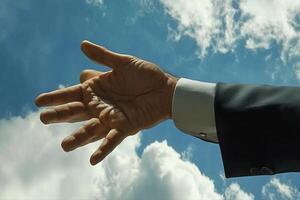 Outstretched hand reaching towards the sky, framed by clouds, symbolizing aspiration photo