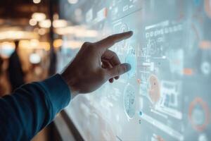 Person interacting with a digital touchscreen interface displaying data and analytics in a modern workspace photo
