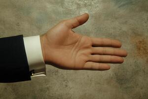 Open hand gesture against a textured background, symbolizing greeting or agreement photo