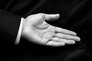 Open hand of a business professional against a dark background, symbolizing readiness photo