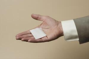 Hand holding a blank card against a neutral background, symbolizing opportunity and potential photo