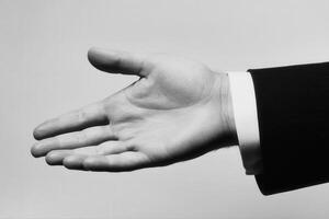 Outstretched hand in a formal suit against a minimalist background, symbolizing invitation photo