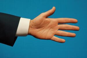 Outstretched hand in a formal suit against a blue background, symbolizing invitation photo