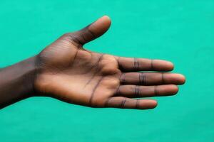 Open hand gesture against a vibrant turquoise background, symbolizing welcome and communication photo