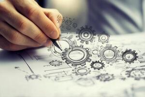 Hand sketching intricate gears on paper, showcasing creativity in engineering design photo
