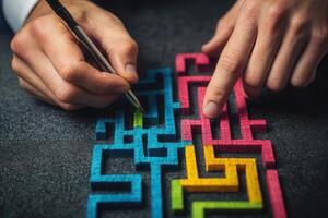 Hands navigating a colorful maze puzzle on a dark surface, showcasing problem-solving skills photo