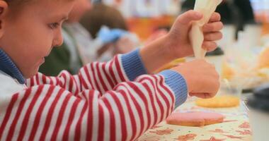Child Decorating Cookies at a Table in a Classroom Setting video