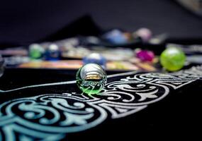 Single transparent marble surrounded by others on soft fabric photo