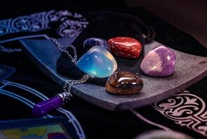 Polished healing crystals displayed on soft black velvet, spiritual and elegant photo