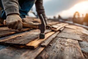 Worker using hammer on wooden roof structure photo