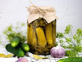 Jar with delicious canned pickles cucumbers on a kitchen table. Close-up. photo