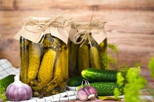 Delicious homemade pickled cucumbers in jars on the table. Close-up. Copy space. photo