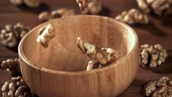 Walnuts fall into a wooden bowl. Filmed on a high-speed camera at 1000 fps. High quality FullHD footage video