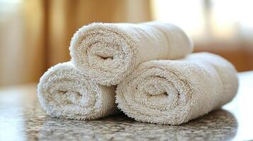 Three white towels on a granite counter photo
