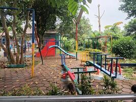 Empty Playground with Colorful Equipment and Lush Greenery photo