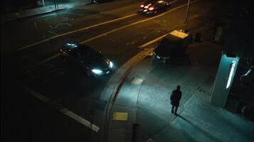 A shadowy street corner illuminated by a drones spotlight showcasing a lone commuter surrounded by the reassuring presence of hovering machines embodying the essence of safety in solitude photo