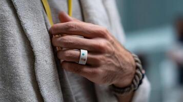 A colorful smart ring on a hand showcasing its minimalist design with a focus on the embedded sensors monitoring biometric data against a casual setting photo
