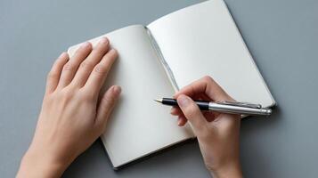 A hand holding a journal open to a blank page with a pen poised above it representing reflection selfdiscovery and the practice of journaling for mental health photo