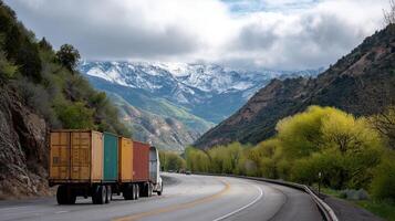 A cargo truck driving along a winding highway loaded with colorful shipping containers with mountains and greenery in the distance photo
