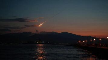 Meteor falling from the sky at sunset over the sea photo
