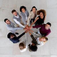 Diverse group of people join hands in a circle. High-angle view photo