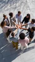 Diverse group stands in circle, hands clasped together photo