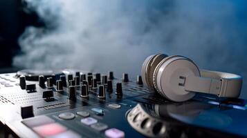 DJ setup with headphones resting on a mixing console. Smoke in the background photo