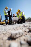 Construction team reviewing plans on site. Workers discussing project details photo