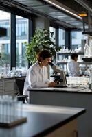 Scientist working at microscope in lab photo
