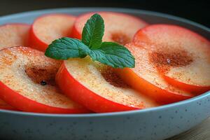 Fresh Apple Slices with Cinnamon and Mint Garnish in Speckled Bowl photo