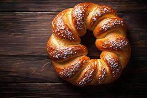 Freshly Baked Twisted Sweet Bread with Sugar Crystals on Rustic Wood Background photo