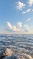 Calm water reflecting cloudy sky with background bottom visible through clear water. Abstract rocky photo