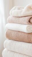 Chunky neutral sweaters stacked neatly, displaying soft wool textures and warm knit colors perfect for cold weather comfort photo