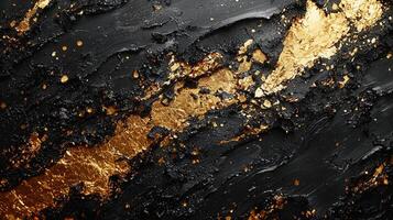 Golden paint abstract over splattering black surface, forming dynamic textured pattern with metallic sheen photo