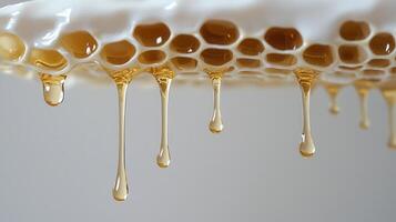 Golden honey cascading from honeycomb, revealing natural amber flow with glossy, sticky texture and rich sweetness photo