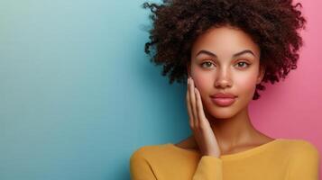 Young black woman with clean, fresh skin standing against a pastel colored background, applying a moisturizing cream to her face, highlighting skincare and beauty routines Copy space for text photo