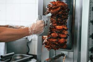 Chef preparing and making traditional, Turkish Doner Kebab meat. Shawarma or gyros photo