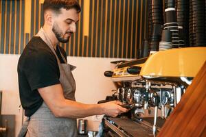 Pours a drink, by ,,using special machine. Man is serving delicious street food photo