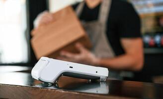 Payment by using terminal,,, order is ready. Man is serving delicious street food photo