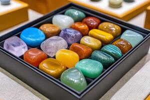 Colorful polished gemstones showing various colors and textures in black display case photo